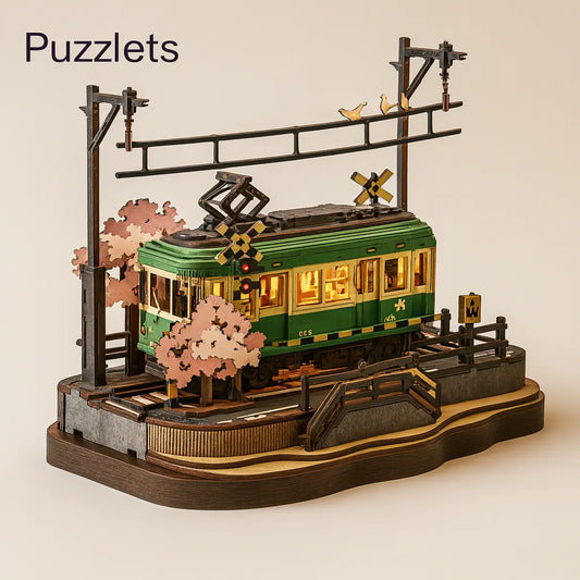 Model of a green tram with cherry blossom trees and a crosswalk sign on a beige background, branded 'Puzzlets'.